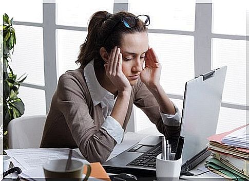 Woman at the computer has a headache